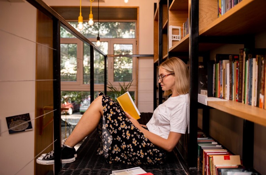 Seseorang yang sedang membaca buku di perpustakaan. (Freepik) - Image