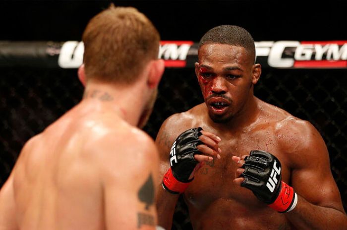 Jon Jones harus terkapar pasca pertandingan meski diputuskan sebagai pemenang dengan kemenangan angka yang tipis. (jp.ufc.com) - Image