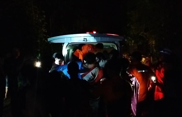 Masyarakat, relawan, dan tim Basarnas memasukkan jenazah korban longsor tambang emas ke dalam ambulans di Kabupaten Solok, Sabtu (28/9) dini hari. (Muhammad Zulfikar/Antara) - Image