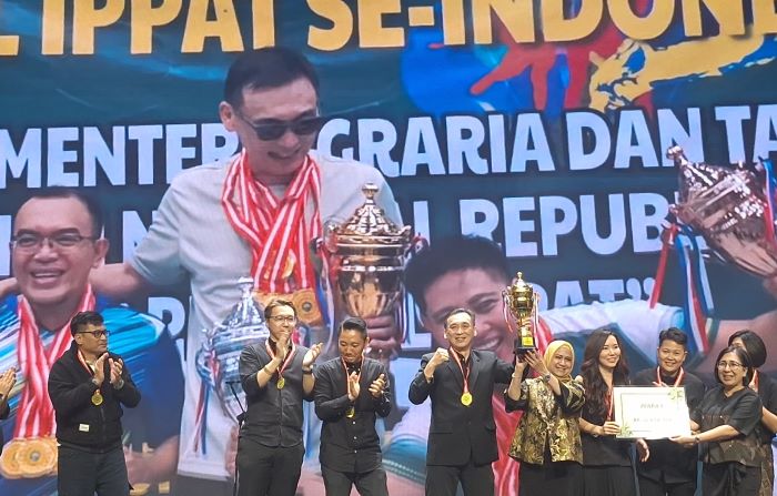 Ketua Pengwil INI Jatim Isy Karimah Syakir mengangkat Piala Bergilir Menteri ATR-BPN usai memenangi turnamen bulu tangkis antar Pengwil IPPAT se-Indonesia. (Istimewa) - Image