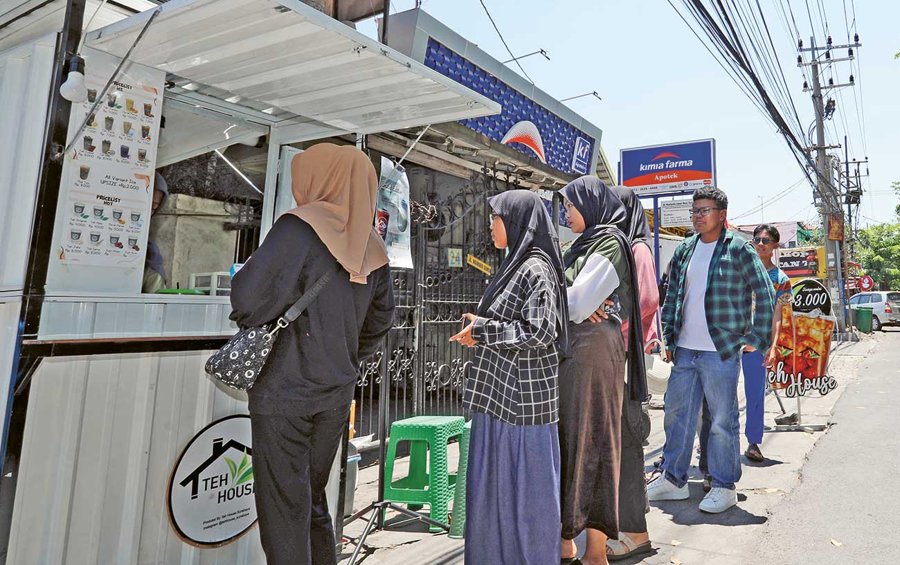 Kios minuman dingin di Jalan Nginden Baru diserbu pembeli kemarin (29/9). Cuaca panas memberikan keuntungan bagi penjual es kristal. Setiap hari dagangan mereka ludes terjual. (PUGUH/JAWA POS) - Image