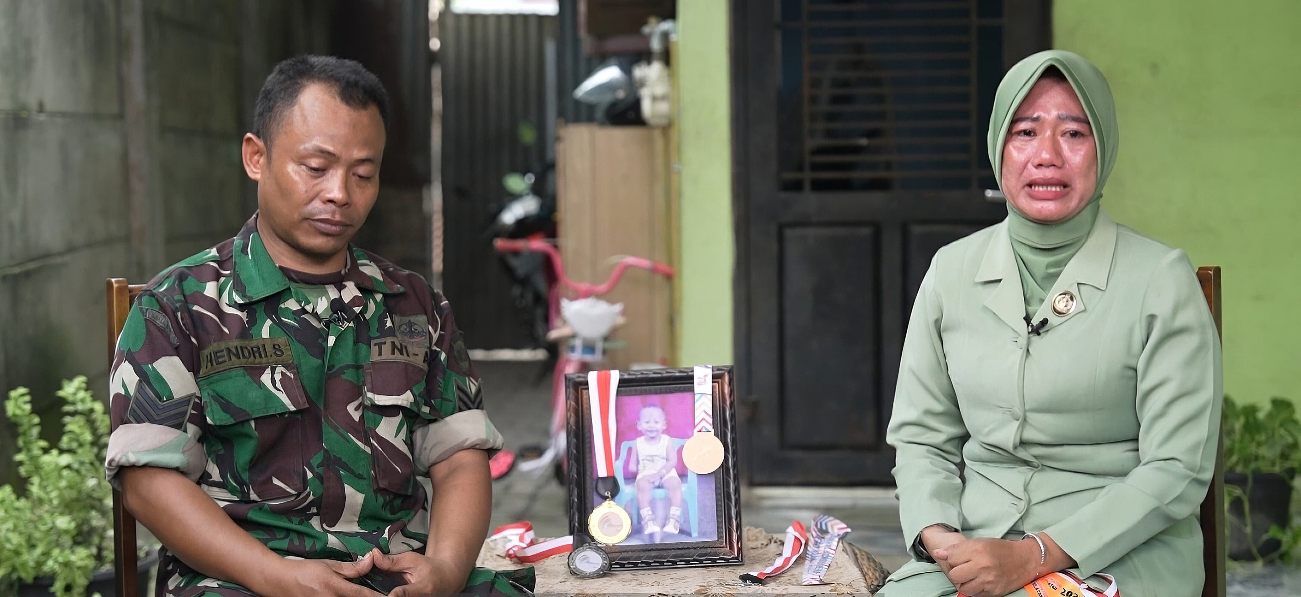 Anggota Kodim Deli Serdang Serka Hendri bersama istrinya saat bercerita tentang Rendi Arif Pratama yang berhasil masuk Polri. (Mabes Polri) - Image