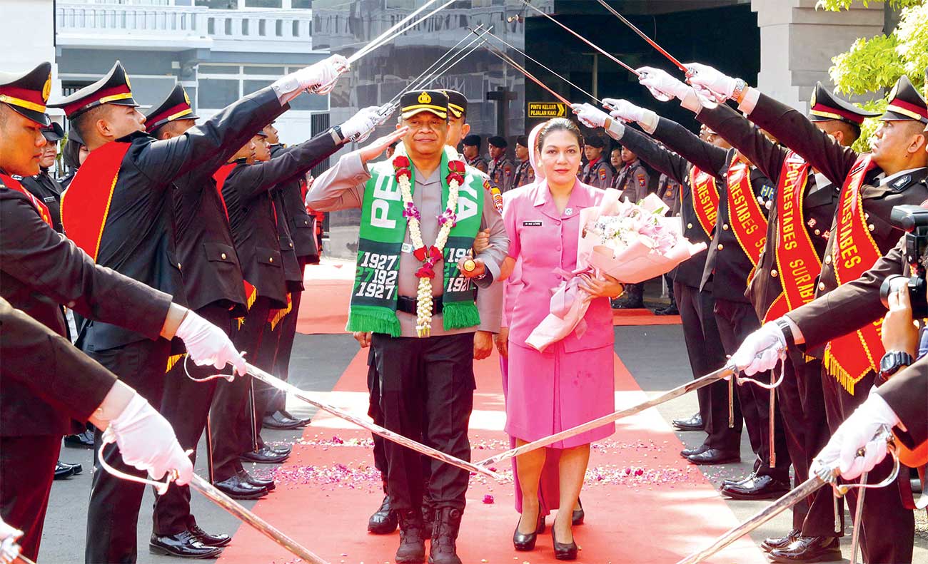 Kapolrestabes Surabaya Kombespol Luthfie Sulistiawan bersama istri mengikuti prosesi pedang pora di mapolrestabes, Jumat (4/10). (Robertus Risky/Jawa Pos) - Image