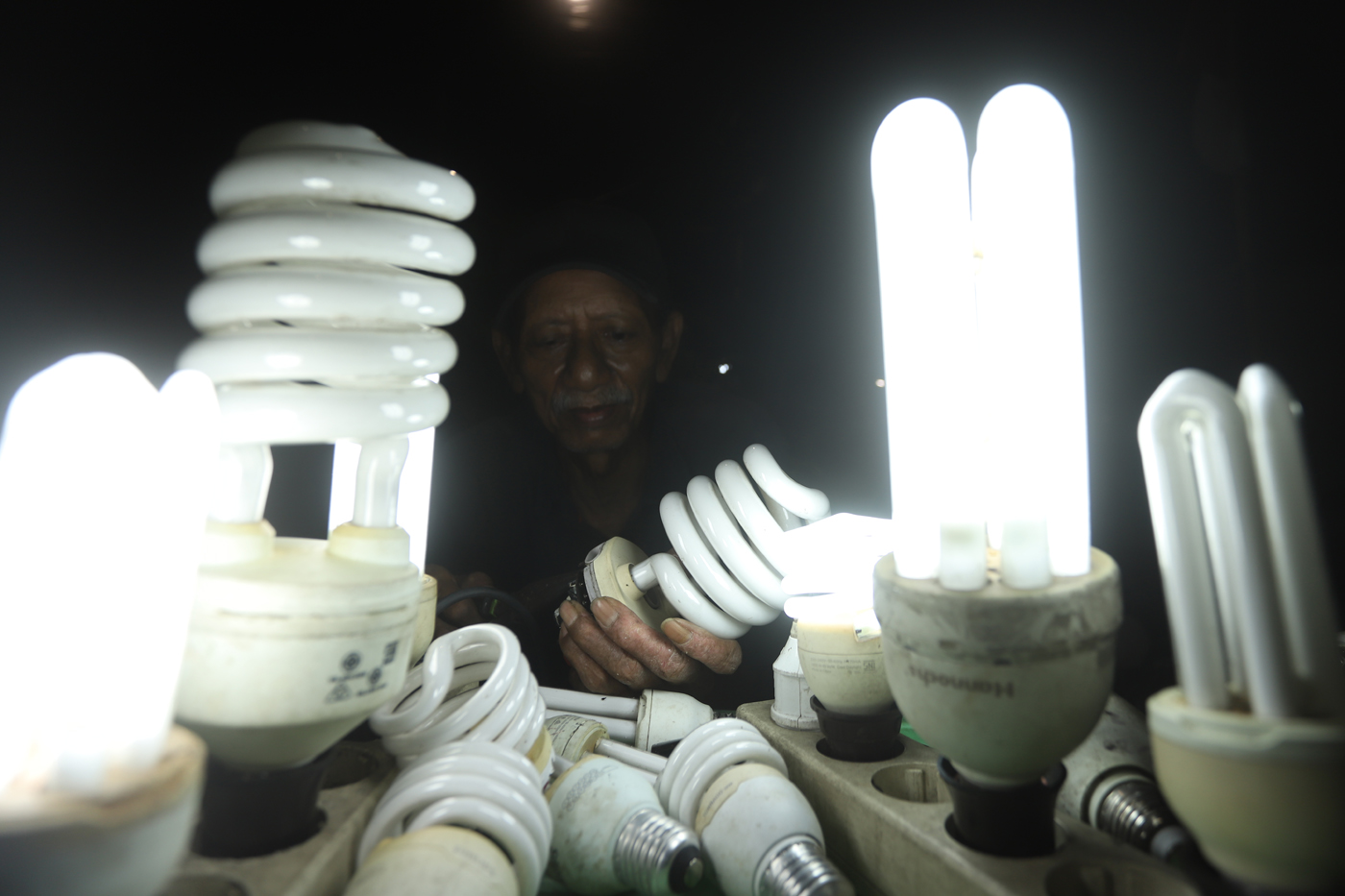 Pak Har (72 Tahun) memperbaiki lampu bohlam di Lapaknya di Kawasan Kebayoran Lama, Jakarta Selatan,