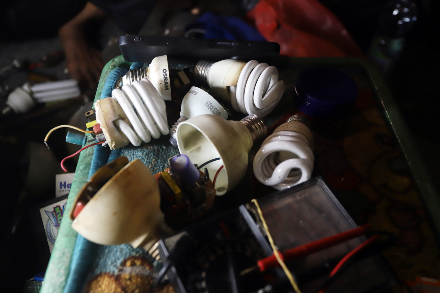 Pak Har (72 Tahun) memperbaiki lampu  bohlam di Lapaknya di Kawasan Kebayoran Lama, Jakarta Selatan,