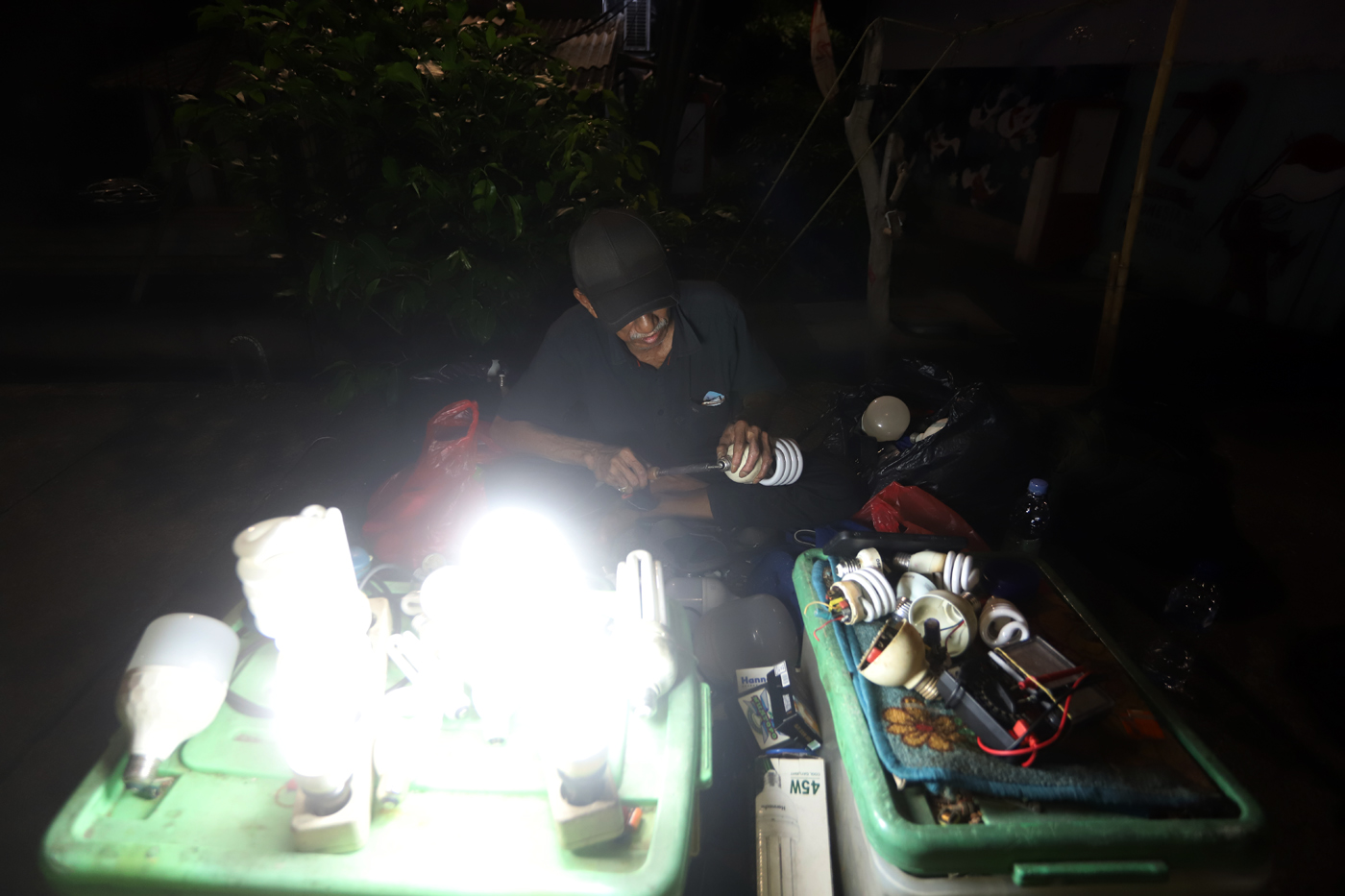 Pak Har (72 Tahun) memperbaiki lampu  bohlam di Lapaknya di Kawasan Kebayoran Lama, Jakarta Selatan,