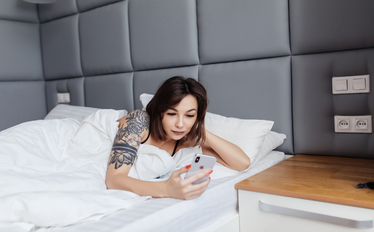 Potret seseorang yang mengecek ponsel bangun tidur. - Image