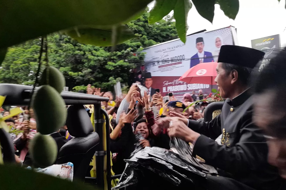 Presiden ke-7 RI Joko Widodo membagikan kaos kepada masyarakat yang menunggunya sejak siang di kawasan Lanud Adi Soemarmo, Boyolali, Minggu (20/10/2024). (MAULIDA AFIFAH/RADAR SOLO) - Image