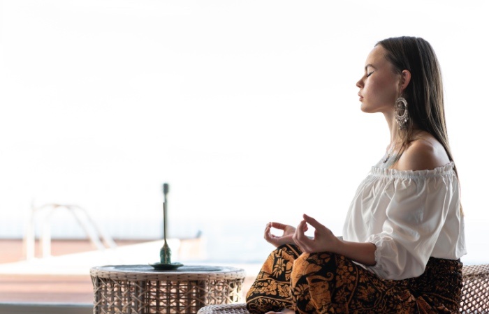 Ilustrasi seorang perempuan yang sedang melakukan meditasi mindfulness. - Image