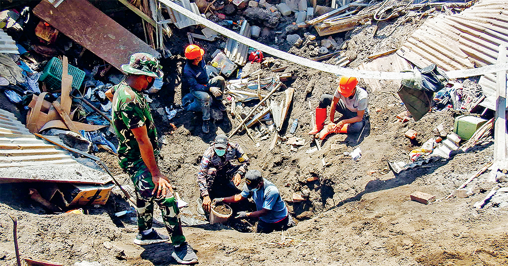 EVAKUASI: Para anggota tim penyelemat mencari korban letusan Gunung Lewotobi Laki-Laki di Desa Klatanlo, Kabupaten Flores Timur, NTT, Senin (4/11). (AFP) - Image