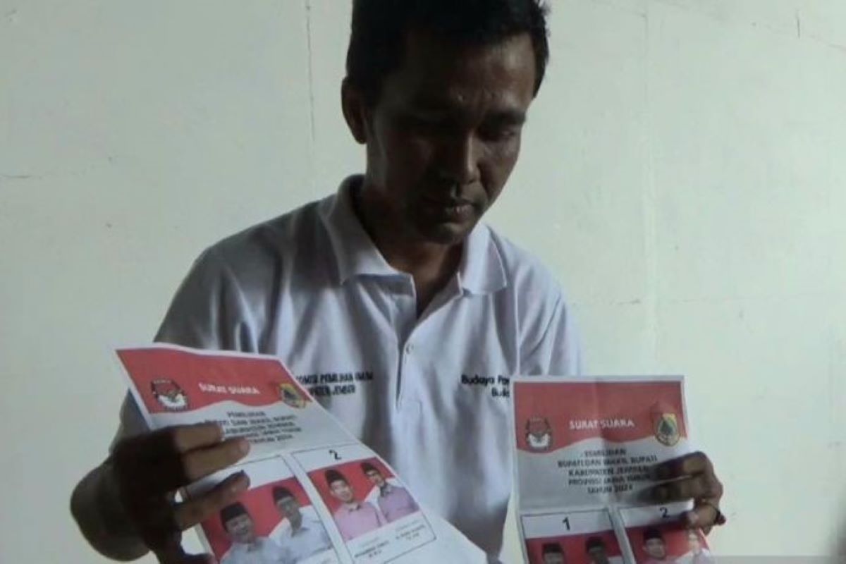 Petugas menunjukkan surat suara yang rusak usai sortir dan pelipatan di gudang KPU Jember. (Zumrotun Solichah/Antara) - Image