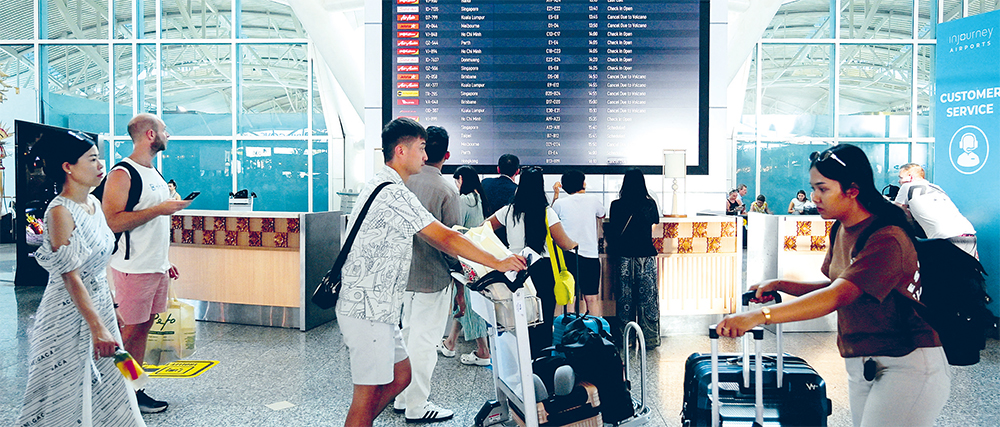 PENERBANGAN BATAL: Papan elektronik di Bandara Ngurah Rai, Badung, Bali, memperlihatkan jadwal penerbangan yang dibatalkan karena dampak erupsi Gunung Lewotobi Laki-Laki, Rabu (13/11). (AFP) - Image