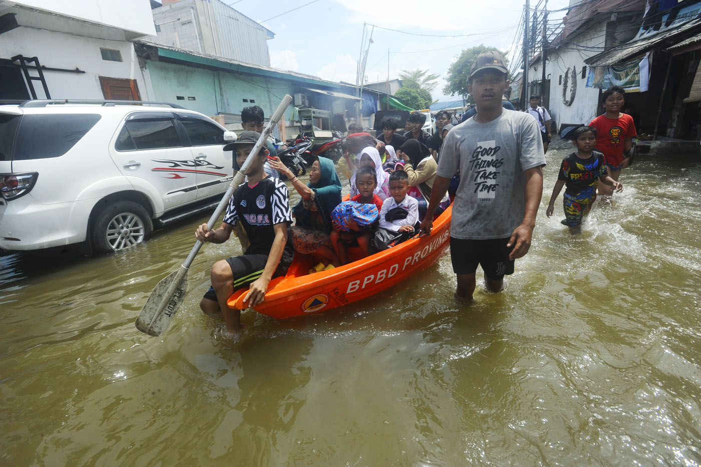 Warna menaiki perahu saat banjir rob menggenangi kawasan Muara Angke, jakarta Utara, Senin (18/11/2024). (Dery Ridwansah/ JawaPos.com) - Image
