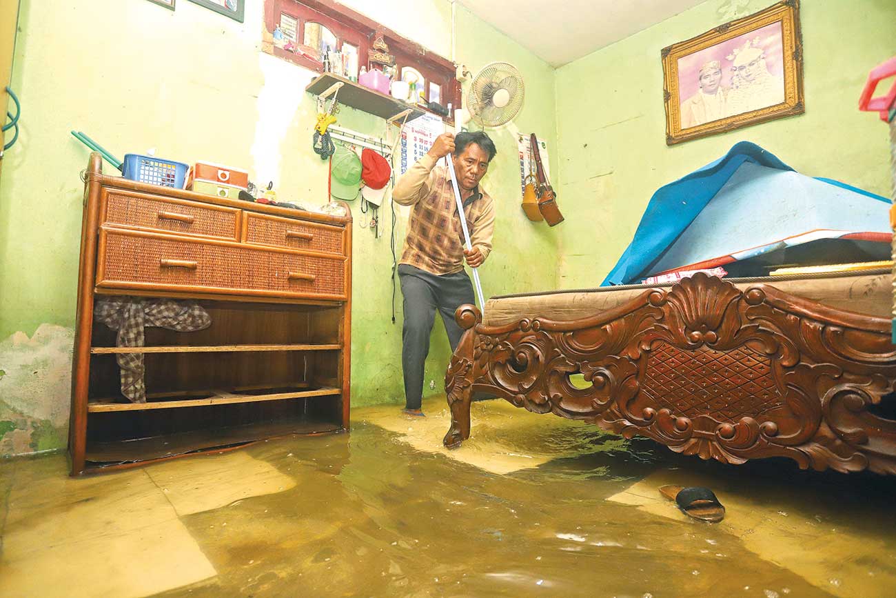 BERSIH-BERSIH: Kamar utama di rumah Mujiono di Greges Timur Gang 1 tergenang hingga semata kaki, Rabu (20/11). (Ahmad Khusaini/Jawa Pos) - Image