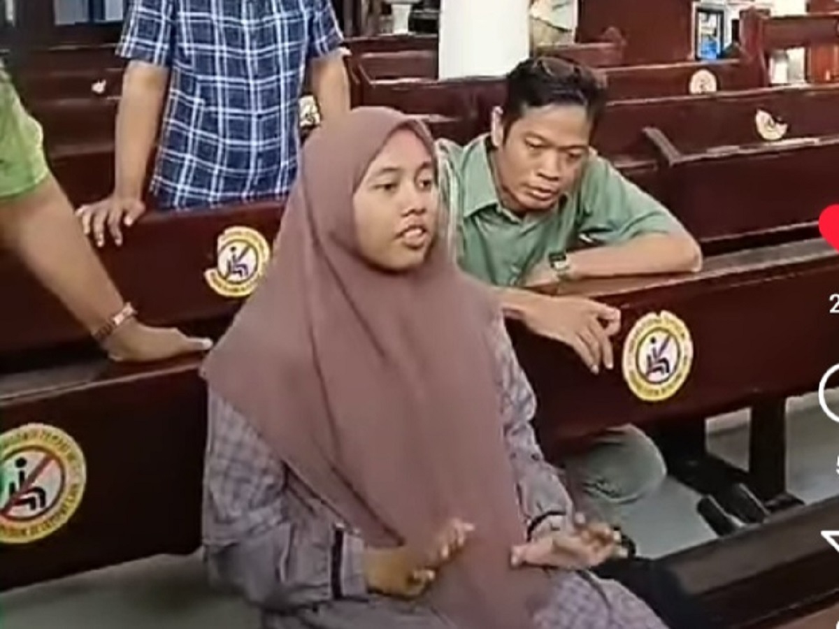 Perempuan berkerudung yang masuk ke dalam Gereja dan membawa senjata tajam sedang ditanyai jemaat Gereja. (Instagram @lyana.lukito) - Image