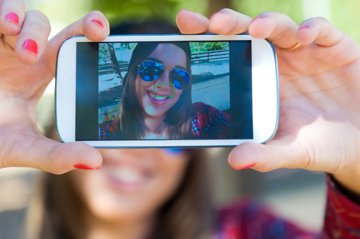 Ilustrasi, seseorang yang menggunakan foto dirinya sendiri sebagai wallpaper handphone. Freepik/ nensuria. - Image