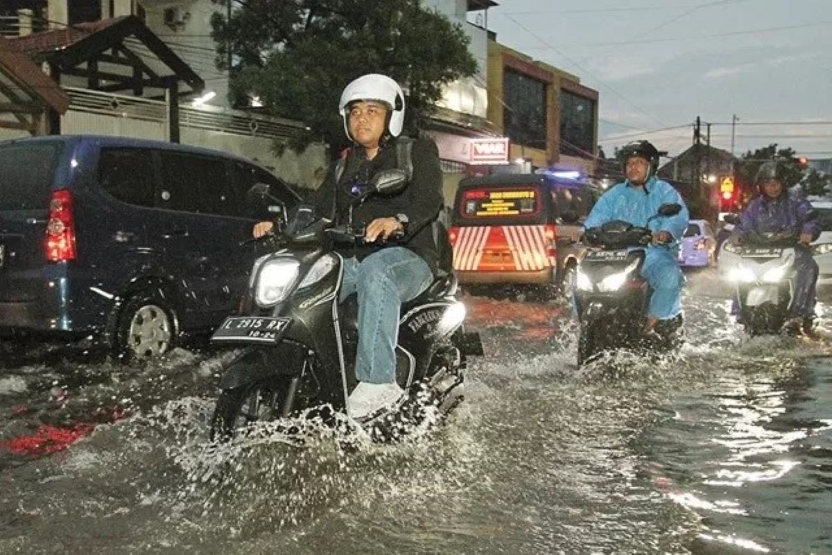Ilustrasi pengendara motor menembus banjir di Jalan Ngagel Timur, Surabaya. (Robertus Risky/Jawa Pos) - Image