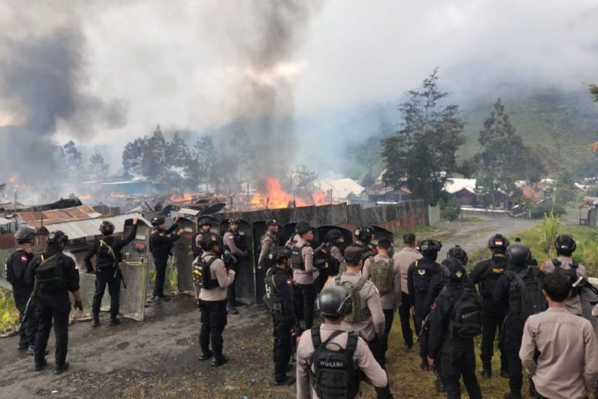 Personel gabungan mengamankan aksi saling serang antar massa pendukung pasangan calon bupati dan wakil bupati di Kabupaten Puncak Jaya. (Humas Polda Papua/Antara) - Image