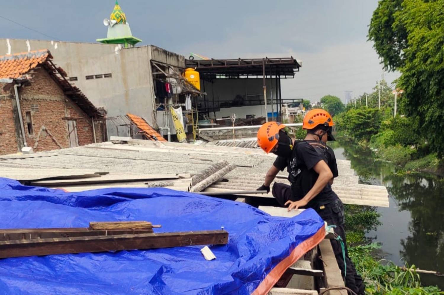 Petugas BPBD Kota Surabaya menangani kerusakan rumah rumah warga di Kelurahan Mulyorejo, Kota Surabaya setelah diterjang angin puting beliung dan hujan lebat. (BPBD Kota Surabaya) - Image