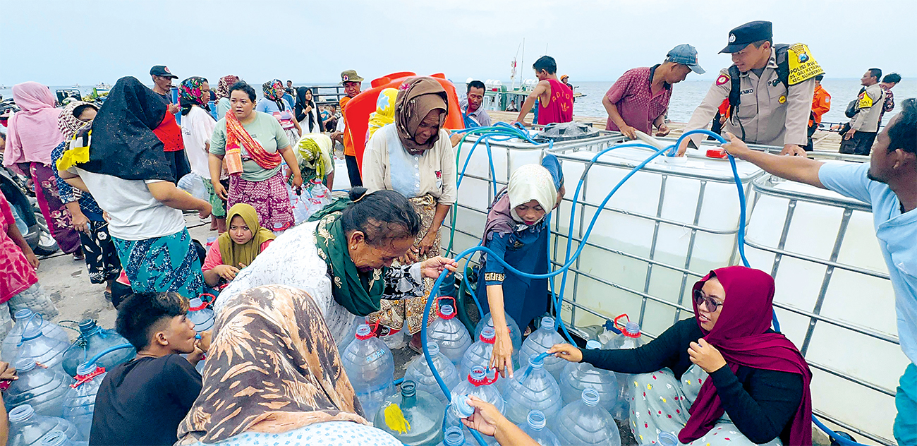 TERDAMPAK: Warga Gili Ketapang, Kabupaten Probolinggo, antre air bersih. (INNNEKE AGUSTIN/JAWA POS RADAR BROMO) - Image