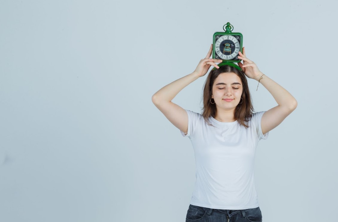 Ilustrasi perempuan memegang jam di atas kepalanya. (freepik) - Image