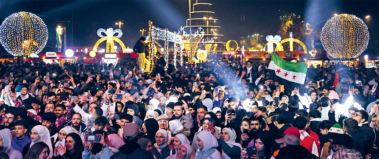 SUKACITA: Warga Syria merayakan pergantian tahun di kawasan Umayyan Square, Damaskus, Syria (31/12/2024). Itu adalah perayaan pertama mereka setelah rezim Al Assad tumbang. (AFP) - Image
