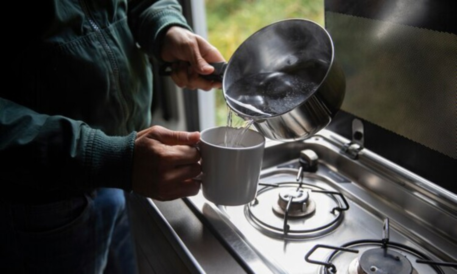 Ilustrasi orang menuang air di atas kompor. (Freepik) - Image
