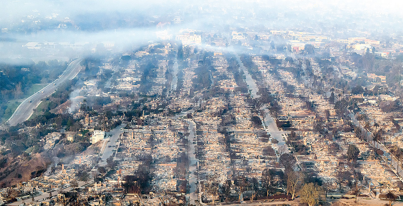 SULIT DIKENDALIKAN: Foto udara memperlihatkan rumah-rumah yang terbakar dekat kawasan Pacific Palisades, Los Angeles (9/1). (JOSH EDELSON/AFP) - Image