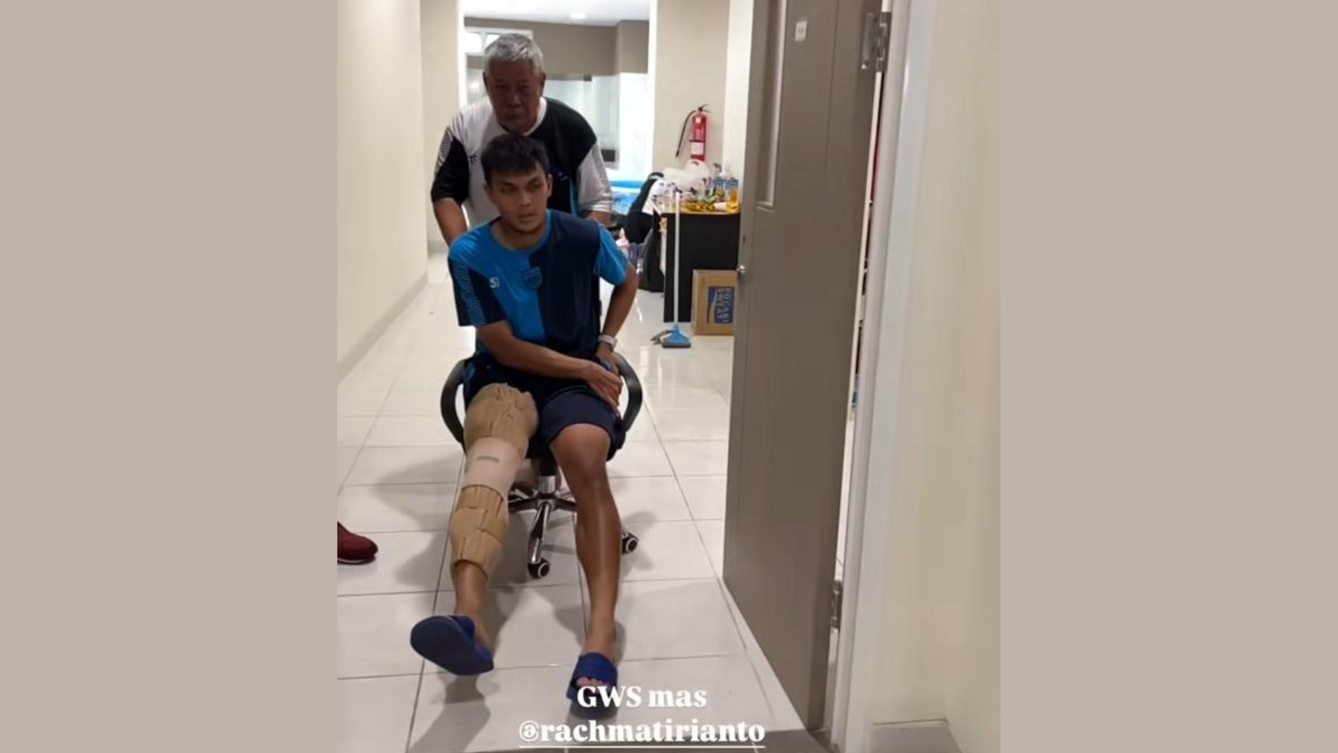 Momen Rachmat Irianto didorong memakai kursi kantor (@persib). - Image