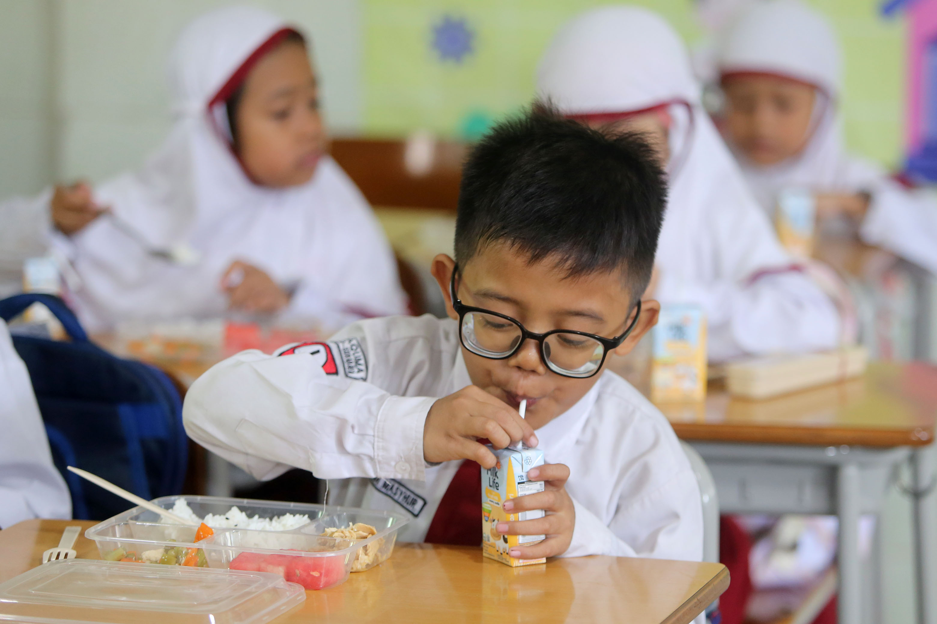 Siswa SD Taquma Surabaya saat menikmati menu Makan Bergizi Gratis. (Humas Pemkot Surabaya) - Image