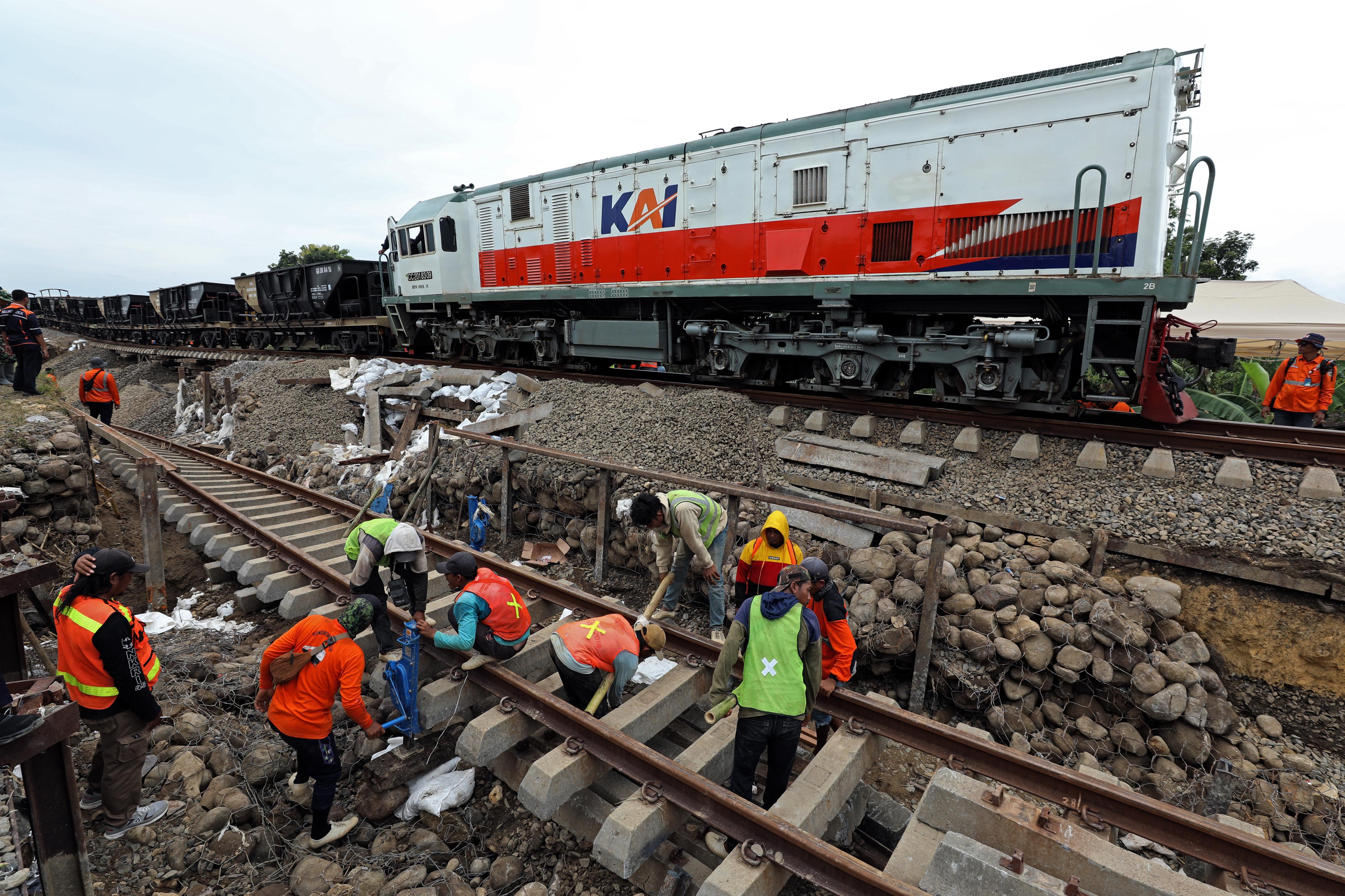 Pekerja memperbaiki jalur kereta api Jakarta-Surabaya yang terdampak banjir di Grobogan, Jawa Tengah pada Kamis (23/1). (BNPB) - Image