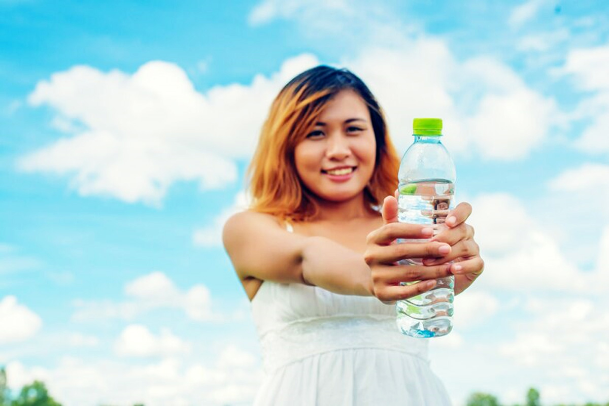 Ilustrasi seorang wanita yang memegang air putih di dalam botol. (Freepik) - Image