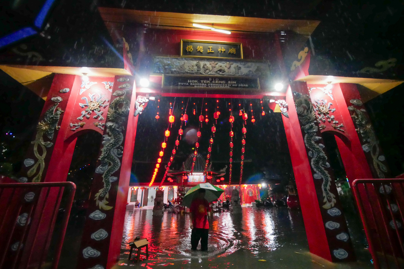 Sejumlah umat Tionghoa berjalan ditengah banjir usai sembahyang Imlek di Vihara Bio Hok Teng Ceng Si