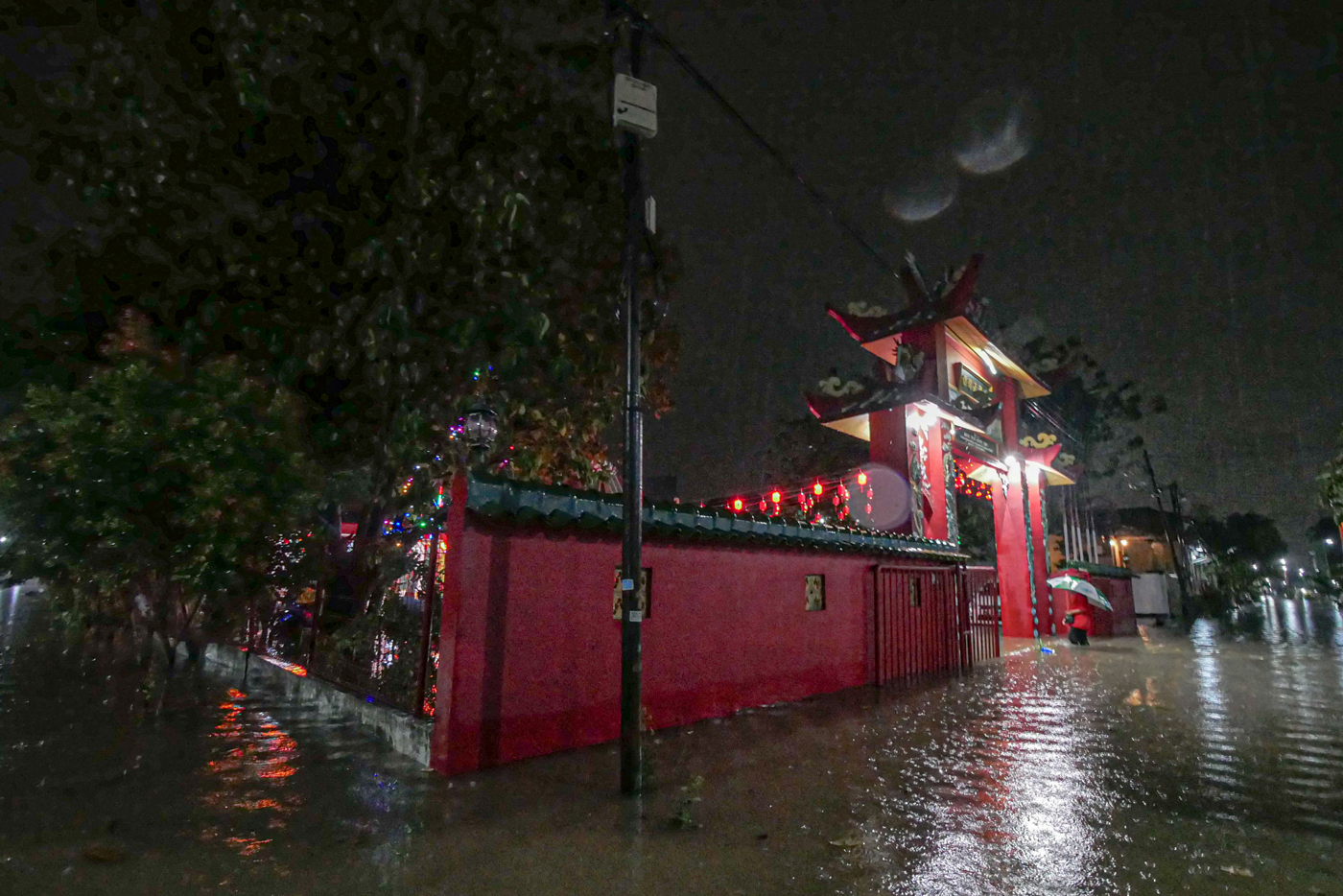 Sejumlah umat Tionghoa berjalan ditengah banjir usai sembahyang Imlek di Vihara Bio Hok Teng Ceng Si