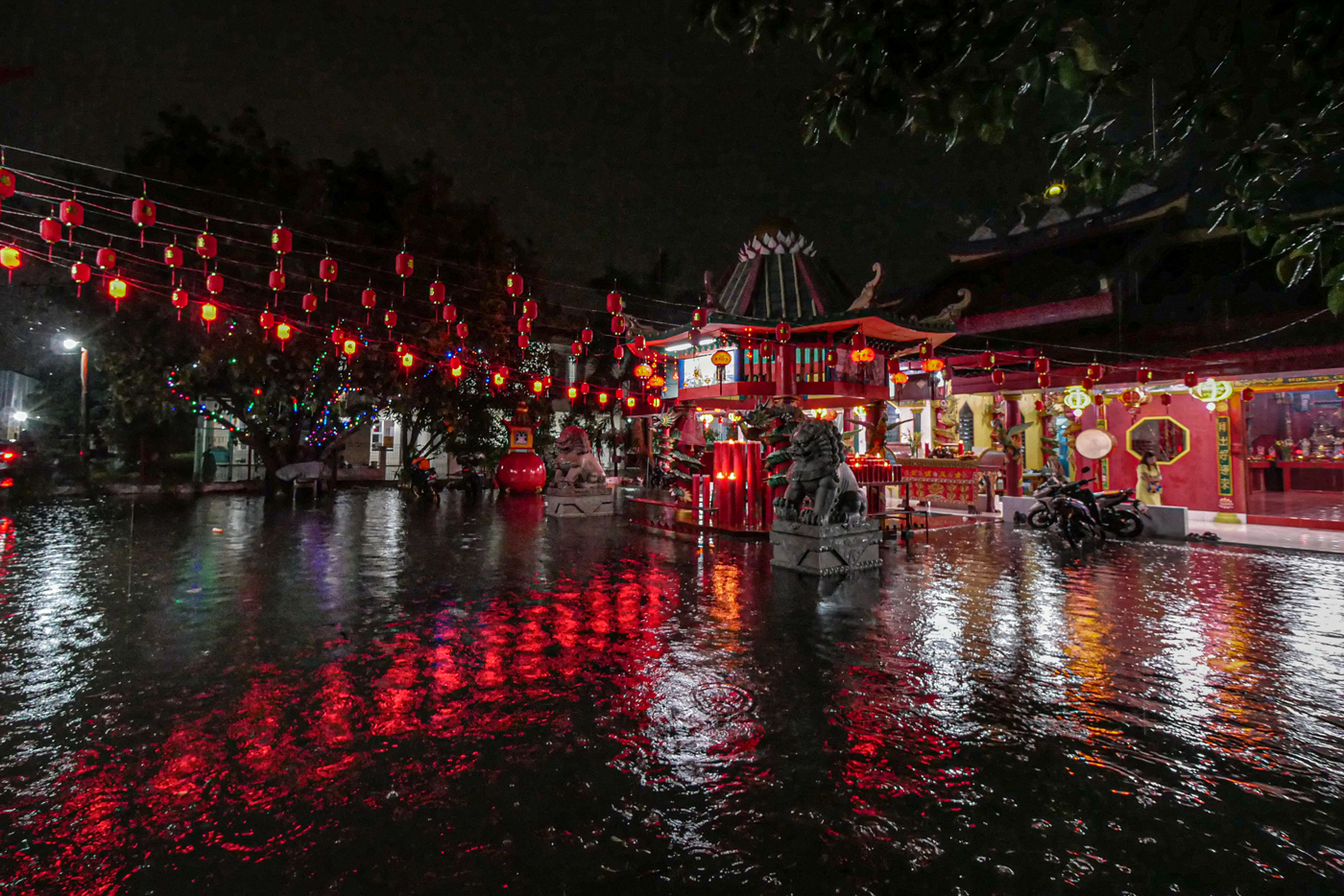 Sejumlah umat Tionghoa berjalan ditengah banjir usai sembahyang Imlek di Vihara Bio Hok Teng Ceng Si
