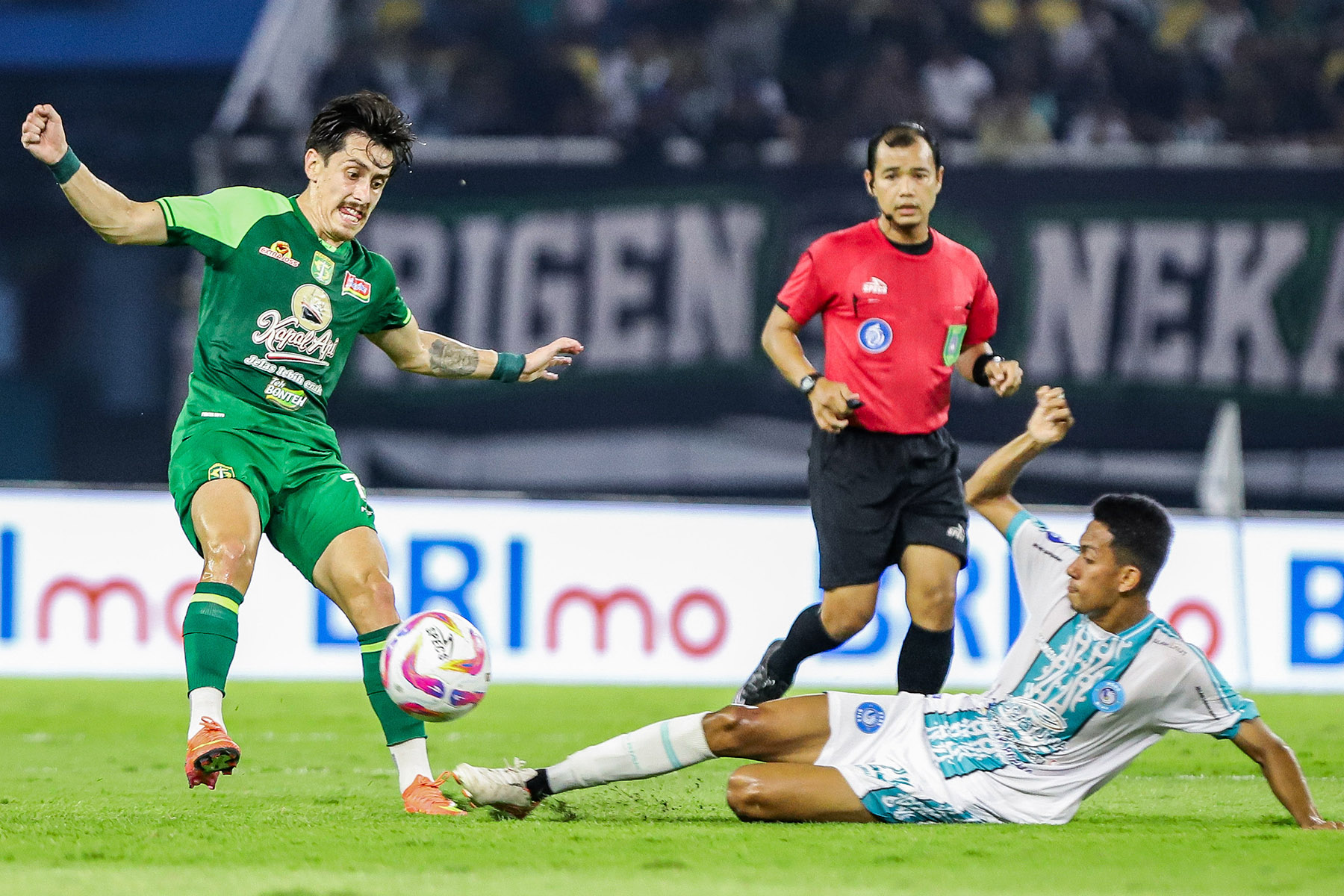 Pemarin Persebaya Rivera berusaha melewati hadangan pemain PSBS Biak Arjuna dalam lanjutan Liga 1 di Stadion Gelora Bung Tomo (15/2). (Riana Setiawan/Jawa Pos) - Image