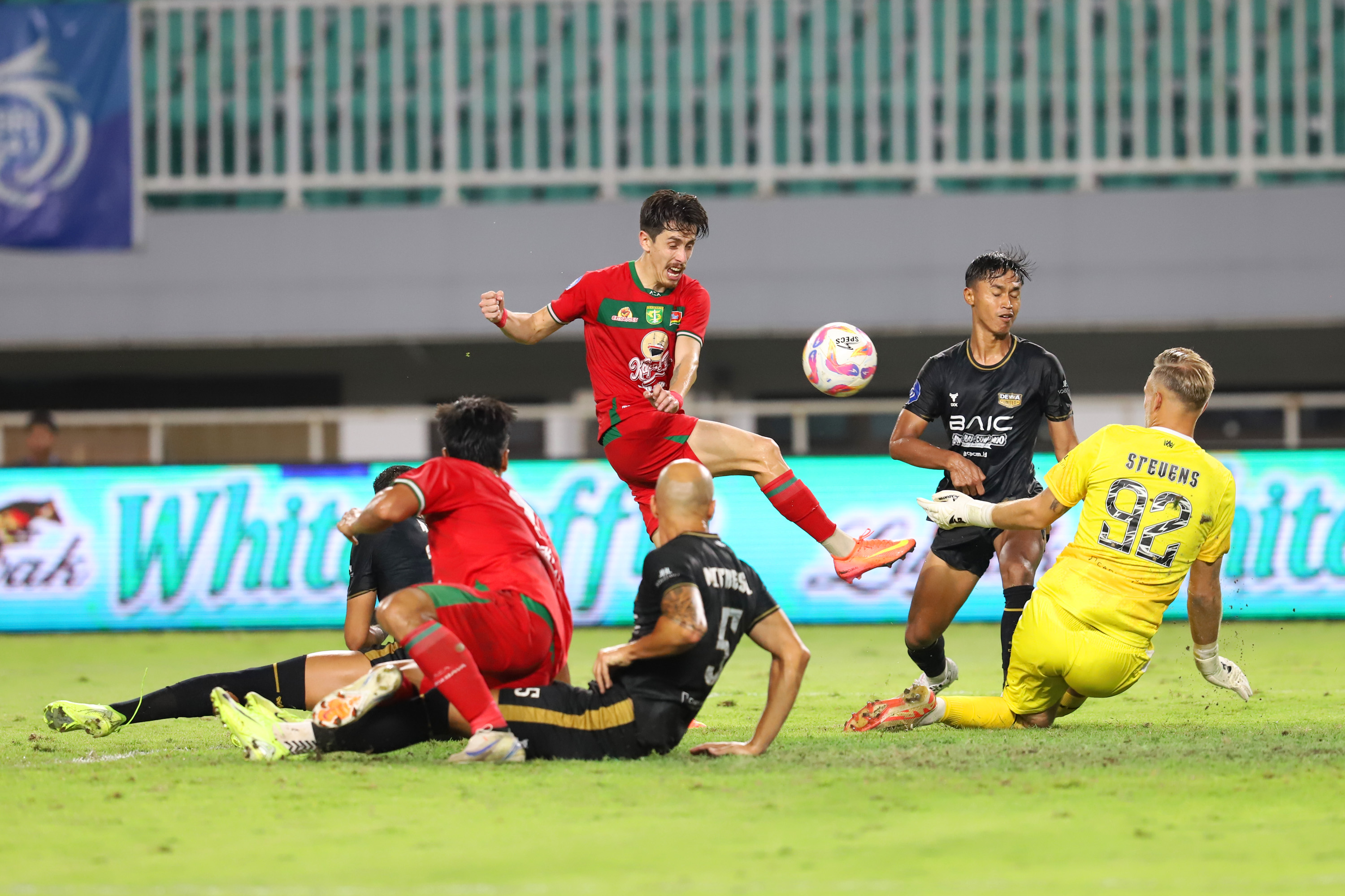Pesepak bola Persebaya Surabaya Francisco Rivera melakukan tembakan yang digagalkan kiper Dewa United Sonny Stevens pada pertandingan Liga 1 2024/2025 di stadion Pakansari, Bogor, Jawa Barat (21/2/2025). (Dery Ridwansah/ JawaPos.com) - Image