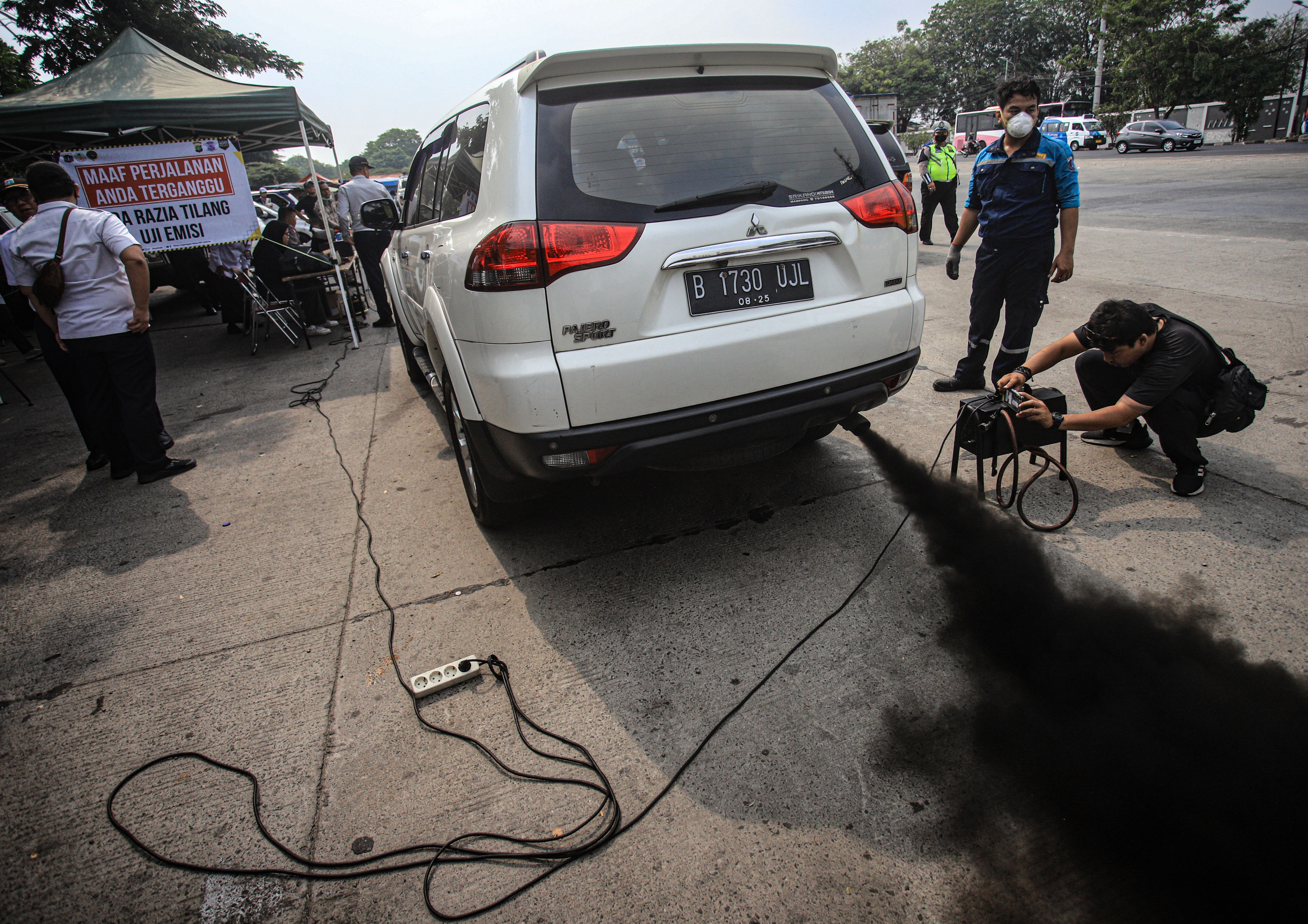 Ilustrasi mobil mengeluarkan asap hitam pekat. (Hanung Hambara/Jawa Pos) - Image