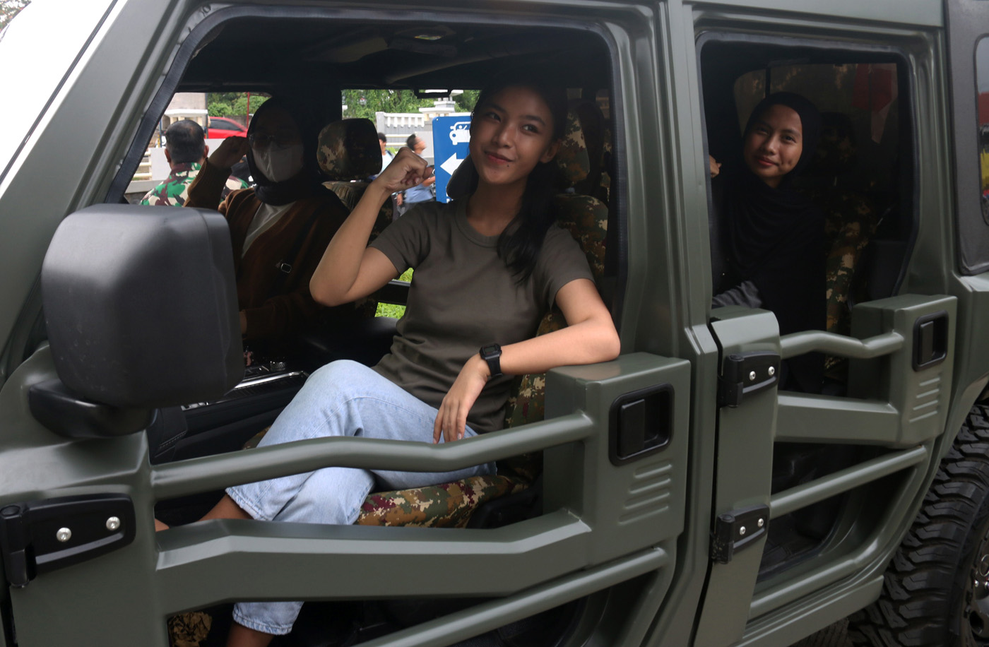 Warga  menaiki kendaraan khusus (Ransus) Jeep Maung MV3 Pindad di sela-sela konvoi dari Makodim 0733