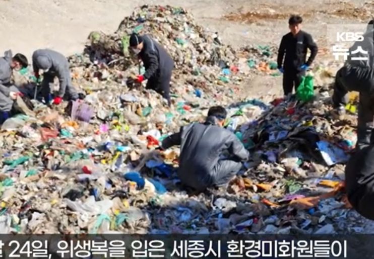 Petugas kebersihan mencari uang yang tidak sengaja dibuang. (YouTube KBS News) - Image