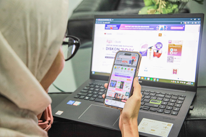 Konsumen lazada saat mengakses website ecommerce Lazada di smart phone dan laptop. (Hanung Hambara/Jawa Pos) - Image