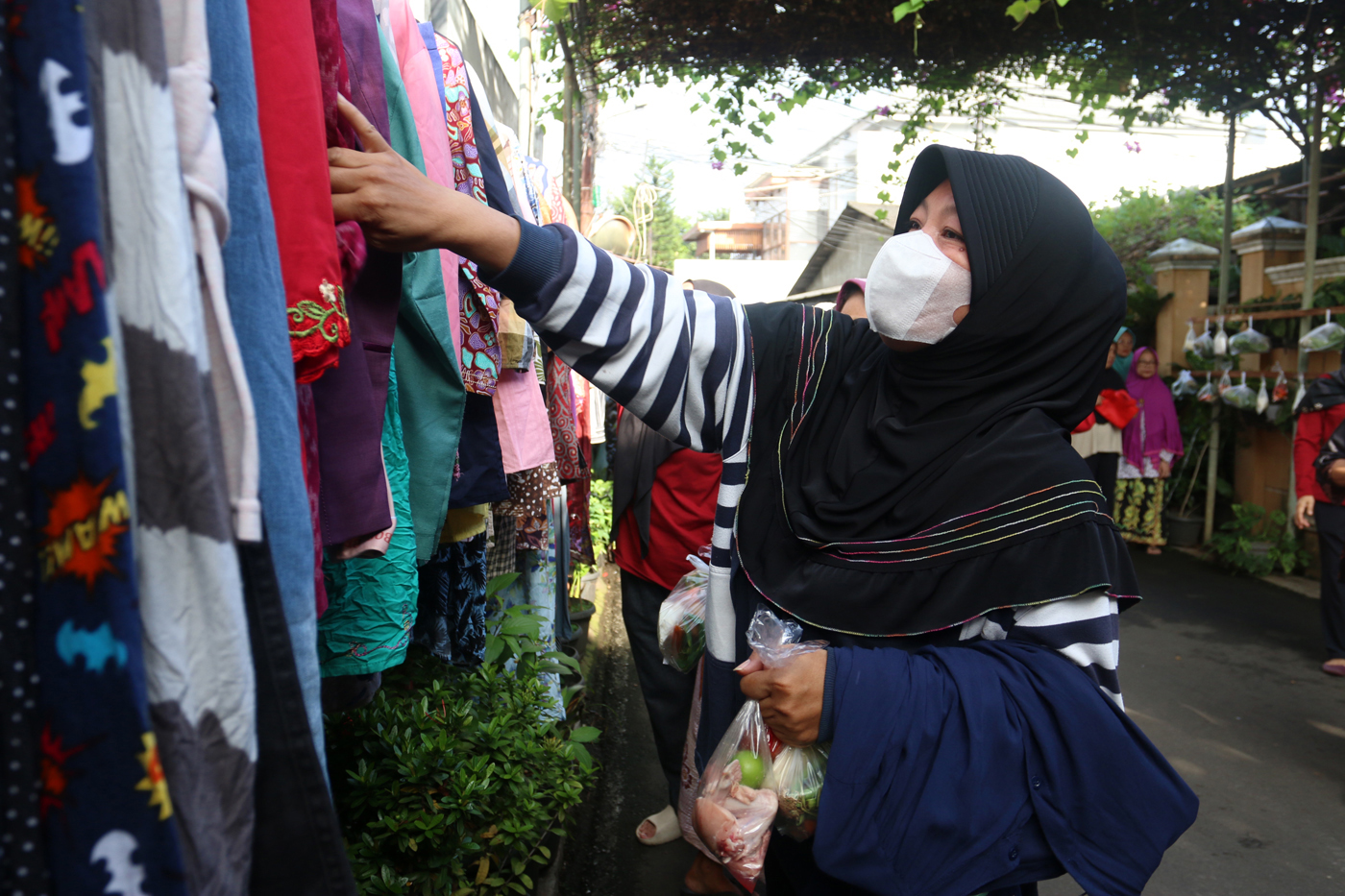 Warga memilih sayur dan pakaian bekas saat bazzar sayuran, bahan makanan dan pakaian layak pakai gra