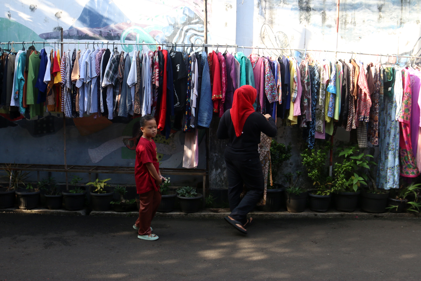 Warga memilih sayur dan pakaian bekas saat bazzar sayuran, bahan makanan dan pakaian layak pakai gra