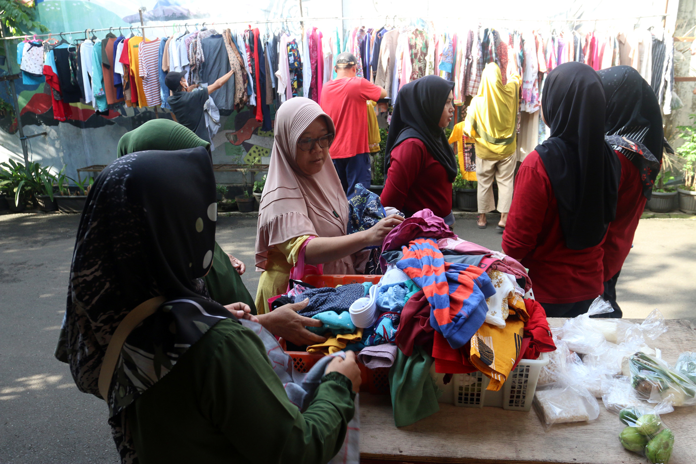 Warga memilih sayur dan pakaian bekas saat bazzar sayuran, bahan makanan dan pakaian layak pakai gra