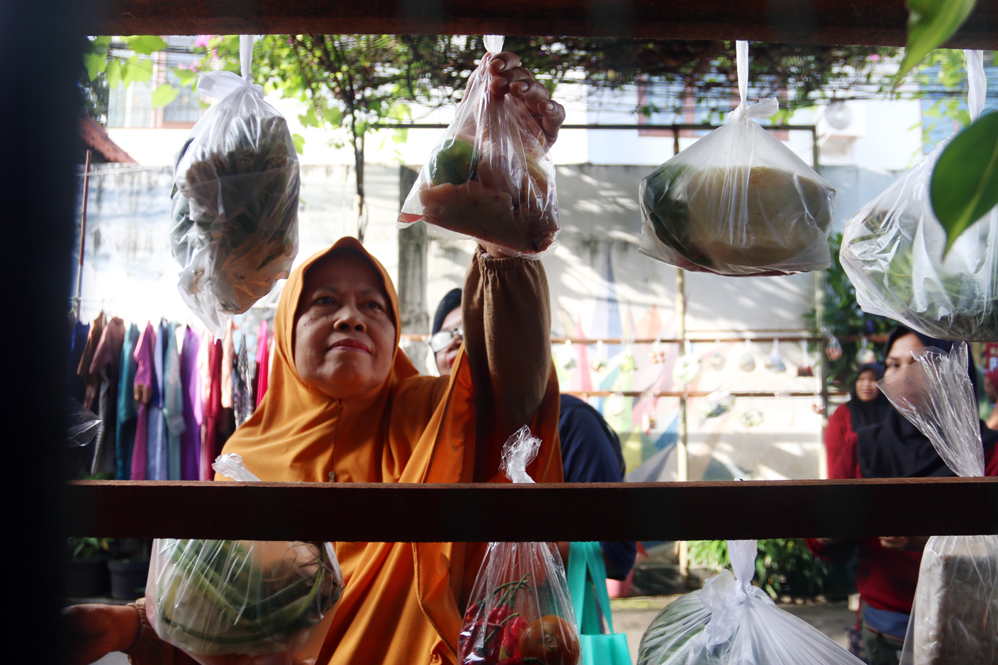 Warga memilih sayur dan pakaian bekas saat bazzar sayuran, bahan makanan dan pakaian layak pakai gra