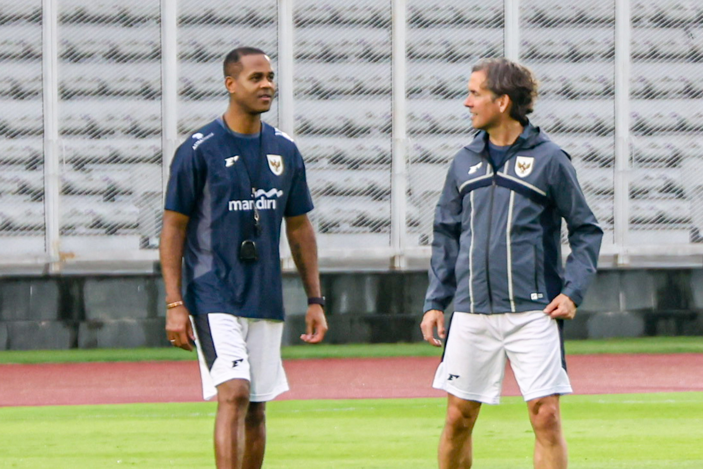 Pelatih Timnas Indonesia Patrick Kluivert (kiri) bersama Alex Pastoor (kanan) memperhatikan anak asuhnya berlatih jelang pertandingan Kualifikasi Piala Dunia 2026 di Stadion Madya, komplek GBK, Senayan, Sabtu (22/3/2025). (Salman Toyibi/Jawa Pos) - Image