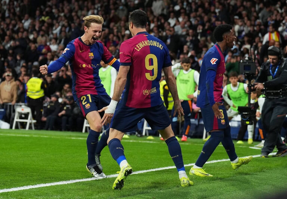 Pemain Barcelona Frenkie De Jong (kiri) dan Robert Lewandowski merayakan gol. (AFP via Jawa Pos) - Image
