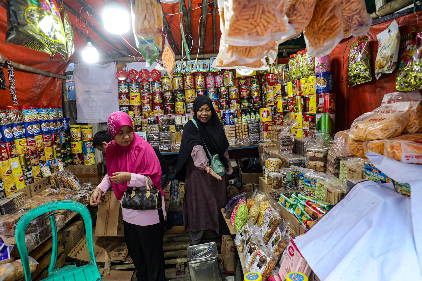 Pedagang melayani pembeli kue kering yang dijual di kawasan Ciracas, Jakarta Timur, Jumat (28/3/2025). (Salman Toyibi/Jawa Pos) - Image