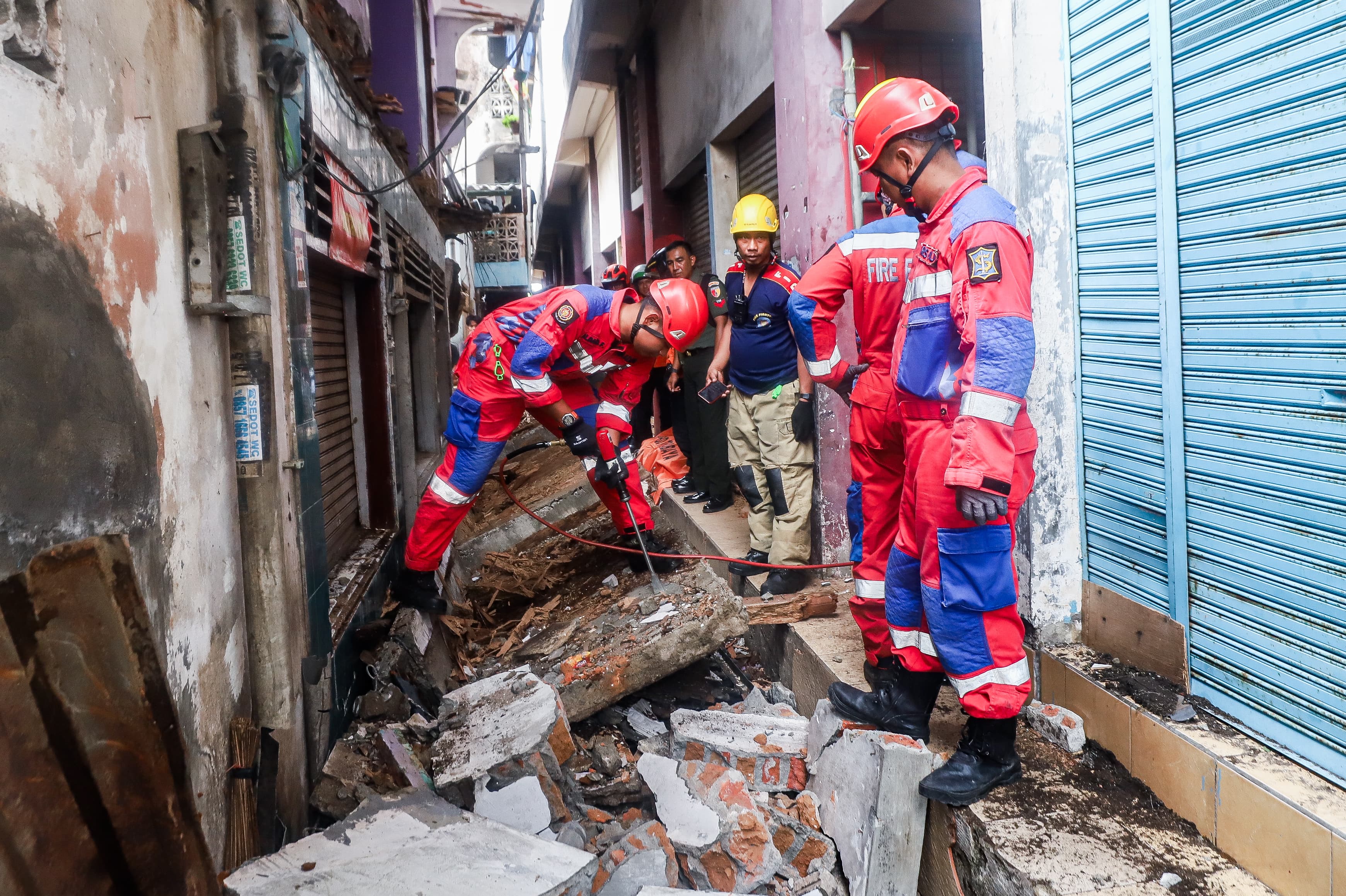 Petugas saat membenahi puing-puing dari bangunan roboh di Kupang Gunung Barat, Surabaya, Selasa (8/4). (Riana Setiawan/Jawa Pos) - Image