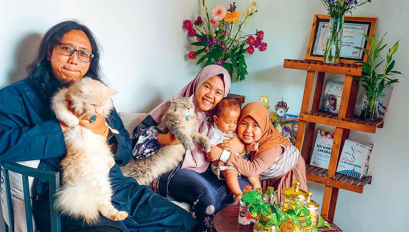 HIDUP BERSAMA: Elvi Robiatul Adawiyah bersama Gunawan, suami, kedua anak, dan anabulnya. Pasutri tersebut menganggap kucing bukan sekadar hewan peliharaan, namun sudah bagian dari keluarga. - Image